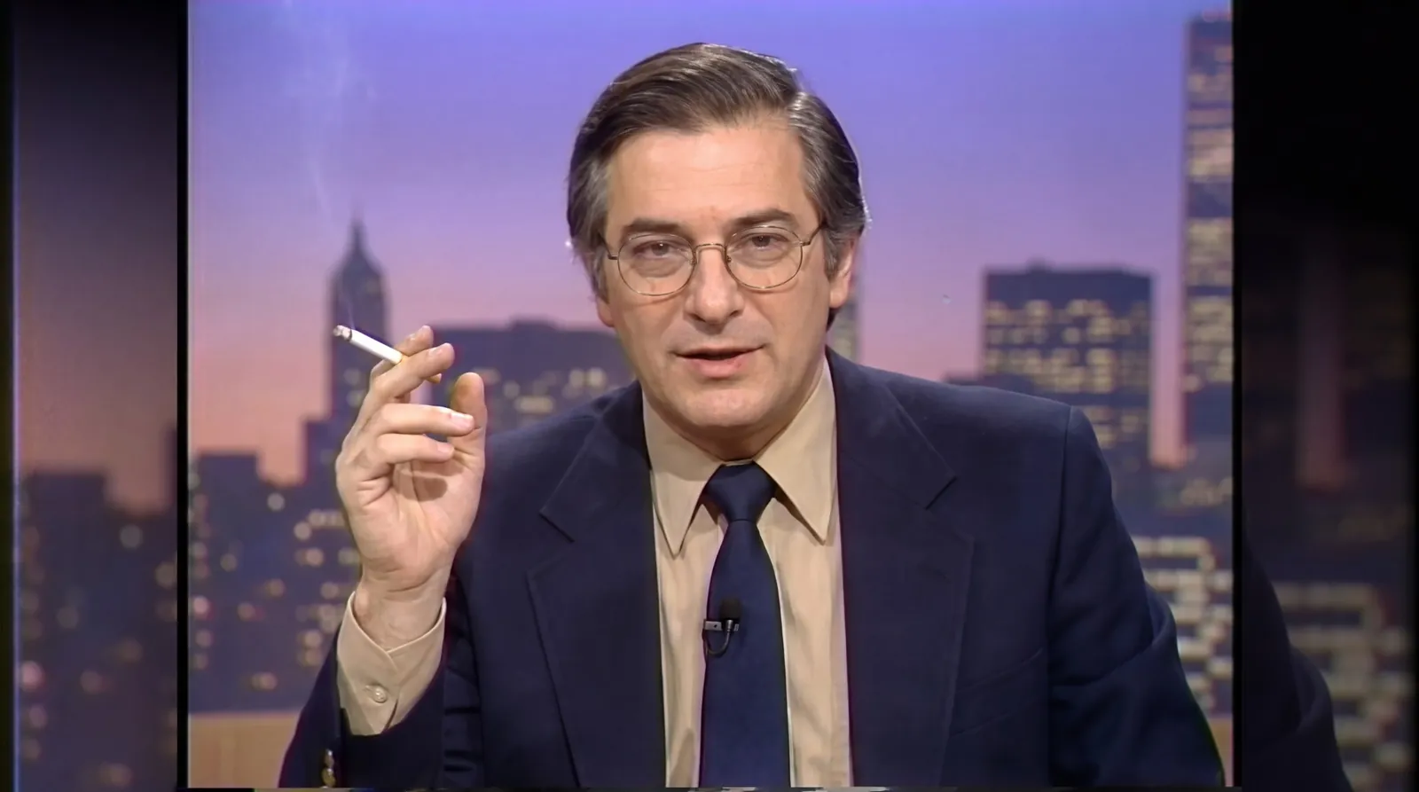 Image made with Nano Banana Pro: a 1980s TV presenter with gold-rimmed glasses talking to camera in front of a city skyline at dusk